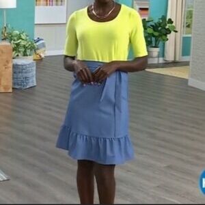 lime green scoop neck short sleeve top and a blue denim-look ruffle hem skirt